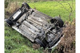 Auto met twee inzittenden op zijn kop op de Rikkert in Andijk