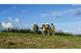 Maaimachine vliegt in brand tijdens maaien van dijk in Wervershoof
