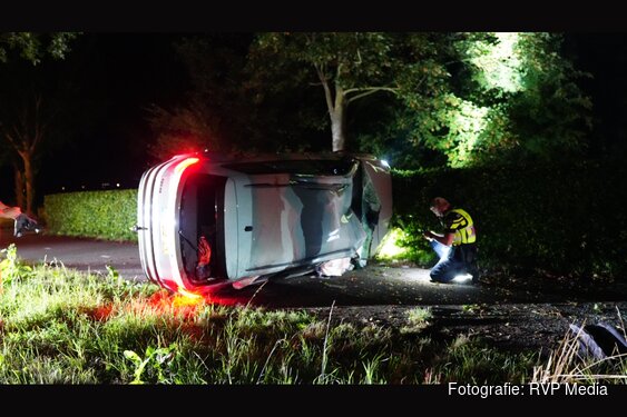 Auto botst tegen boom en komt op zijkant tot stilstand in Oostwoud