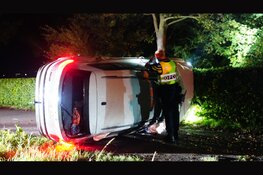 Auto botst tegen boom en komt op zijkant tot stilstand in Oostwoud