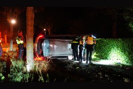 Auto botst tegen boom en komt op zijkant tot stilstand in Oostwoud