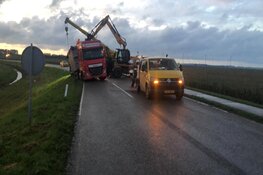 Vrachtwagen met trailer in berm